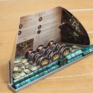 May include: A game organizer for the A Game of Thrones: The Card Game, featuring a Tyrell house card, a grey plastic organizer with green and brown tokens, and a card depicting a knight on horseback.