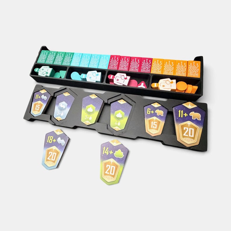 K&ouml;nnte beinhalten: Ein schwarzer Kunststoff-Organizer f&uuml;r Brettspiele mit rechteckigen Pl&auml;ttchen mit Schaltkreismustern in Gr&uuml;n, Blau, Pink und Orange sowie Charakter-Spielsteinen und schildf&ouml;rmigen Karten mit den Zahlen 6+, 11+, 14+, 15, 18+ und 20.