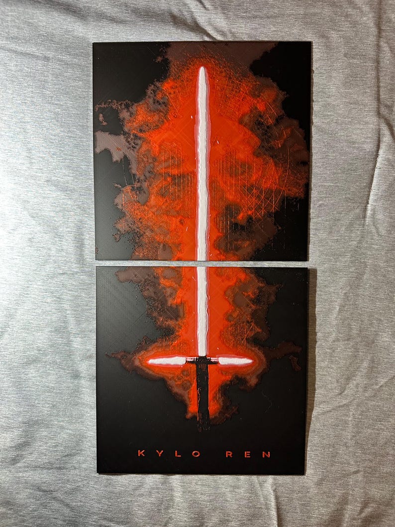 K&ouml;nnte beinhalten: Zwei quadratische schwarze Tafeln mit einem wei&szlig;en und roten Lichtschwert-Design. Das Lichtschwert ist vertikal mit einem roten Schein. Der Text "KYLO REN" steht unten in Rot.