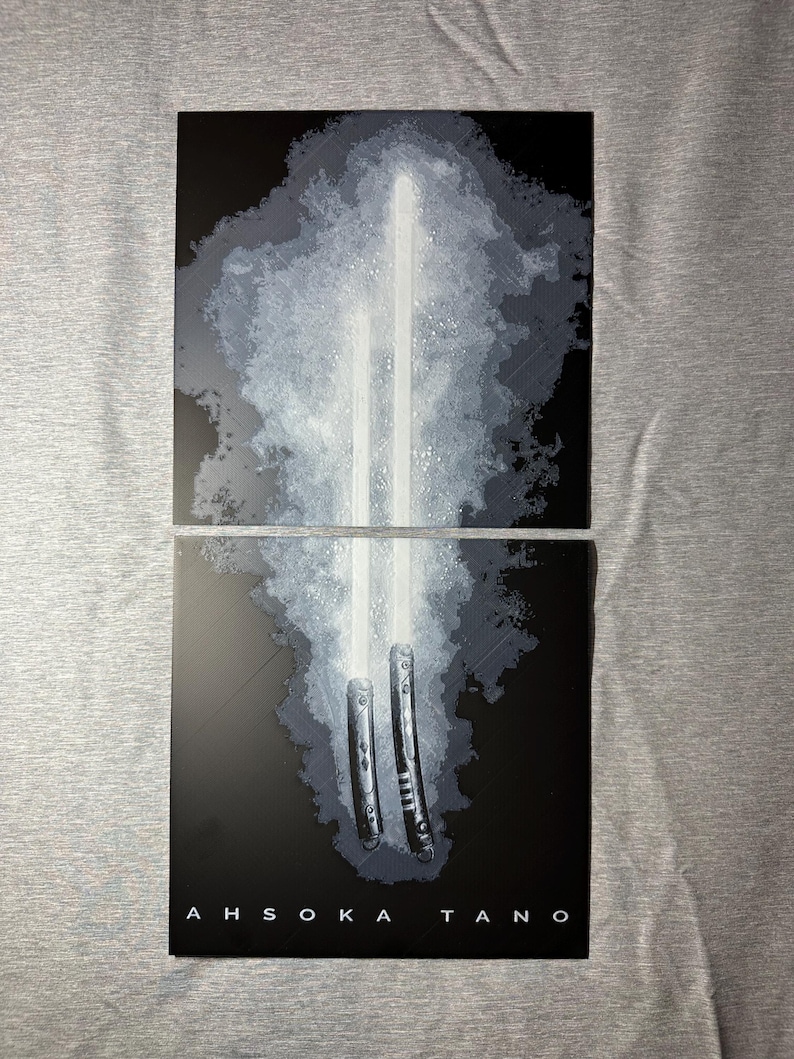 K&ouml;nnte beinhalten: Zweiteiliges Kunstwerk mit wei&szlig;en Lichtschwertern vor einem rauchigen, grauen Hintergrund. Das untere Feld zeigt den Text "AHSOKA TANO" in wei&szlig;en Gro&szlig;buchstaben. Das Kunstwerk hat eine dunkle, dramatische &Auml;sthetik, wobei der Fokus auf dem hellen Gl&uuml;hen der Lichtschwerter liegt.