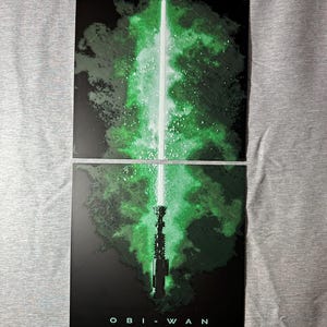 K&ouml;nnte beinhalten: Zweiteiliges Kunstwerk mit einem gr&uuml;nen Lichtschwert vor dunklem Hintergrund mit einem gr&uuml;nen und wei&szlig;en Nebel-Effekt. Das Wort "OBI-WAN" ist unten in Wei&szlig; aufgedruckt.