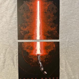 K&ouml;nnte beinhalten: Zwei rechteckige Drucke mit einem roten Lichtschwert vor dunklem Hintergrund. Der obere Druck zeigt die Klinge, w&auml;hrend der untere den Griff und den wei&szlig;en Text "COUNT DOOKU" enth&auml;lt.