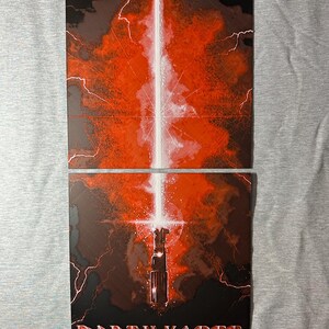 K&ouml;nnte beinhalten: Zweiteiliges Kunstwerk mit rotem und schwarzem Hintergrund und einem wei&szlig;en Lichtschwert. Der untere Teil zeigt den Text "Darth Vader" in Rot. Blitzartige Streifen sind im gesamten Kunstwerk sichtbar.