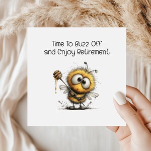 May include: A square greeting card with the text "Time To Buzz Off and Enjoy Retirement". The card features a cartoon bee holding a honey dipper. The bee is yellow and black with large eyes and small wings.