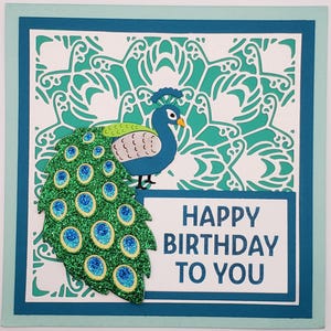 Cartão de aniversário feito à mão com um lindo pavão com uma cauda brilhante com o sentimento "Parabéns a você" em um cartão 6x6
