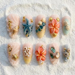 May include: A set of ten artificial nails with a beach theme. Each nail features a different design, including seahorses, starfish, shells, and flowers, with gold accents. The nails are painted in shades of pink, blue, and yellow.