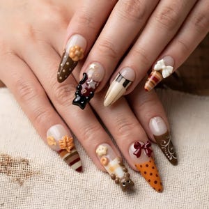 Peut inclure: Ongles en amande arborant divers motifs sur le thème de l'automne, notamment des pois marron, des étoiles blanches, des rayures et des ornements 3D comme des petites fleurs, des nœuds et une figurine d'ours dans des tons marron, orange et crème.