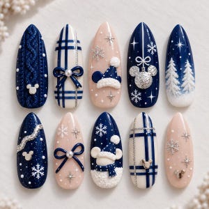 Puede incluir: Un juego de diez uñas postizas en forma de almendra con diseños invernales y festivos. Los patrones incluyen tejido de punto azul marino, cuadros azules y blancos con lazos, fondos nude con copos de nieve, iconos de Mickey y pinos.