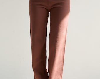 Op de afbeelding: Een paar brede, bruine broek van zachte gebreide stof. De broek heeft een hoge taille en een ontspannen pasvorm.