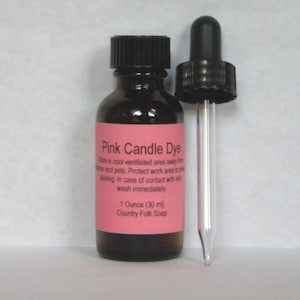 May include: A small brown glass bottle with a dropper top filled with pink candle dye. The bottle label reads "Pink Candle Dye" and includes instructions for use and storage. The label also states "1 Ounce (30 ml) Country Folk Soap."