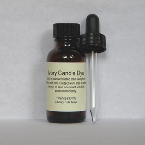 May include: A small brown glass bottle with a black dropper top. The bottle is labeled "Ivory Candle Dye" and contains 1 ounce (30 ml) of dye. The label also includes instructions for storage and safety.