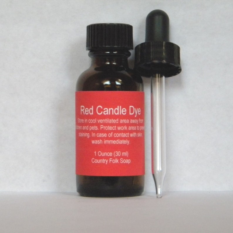 May include: A small brown glass bottle with a black dropper cap. The bottle is labeled "Red Candle Dye" and contains 1 ounce (30 ml) of dye. The label also includes instructions for safe use and storage. The bottle is sitting on a white surface.