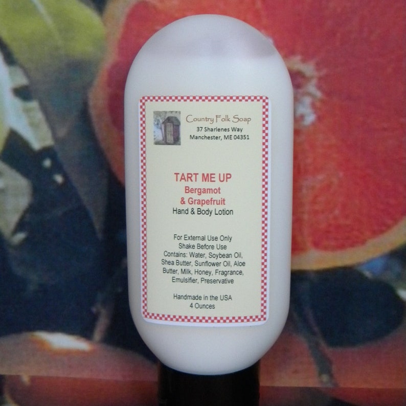 May include: A white plastic bottle of hand and body lotion with a red and white checkered label. The label reads "Country Folk Soap", "TART ME UP", "Bergamot & Grapefruit", "Hand & Body Lotion", "For External Use Only", "Shake Before Use", "Contains: Water, Soybean Oil, Shea Butter, Sunflower Oil, Aloe Butter, Milk, Honey, Fragrance, Emulsifier, Preservative", "Handmade in the USA", and "4 Ounces".
