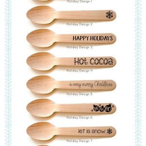 May include: Eight wooden spoons with different holiday-themed designs. The designs include "Merry Christmas", a snowflake, "Happy Holidays", "Hot Cocoa", "a very merry Christmas", "HO HO HO" with ornaments, "let it snow" with a snowflake, and "COMFORT & JOY".