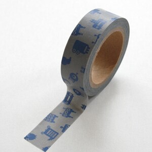 May include: A roll of gray washi tape with a repeating pattern of blue robots. The tape is partially unrolled, showing the design.