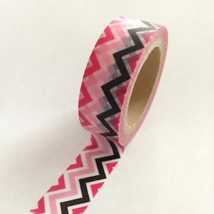 May include: Pink and black chevron patterned washi tape on a white background.