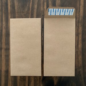 以下が含まれることがあります： 茶色の紙の封筒が2つ、1つは上部に青と白のストライプのシールが付いています。