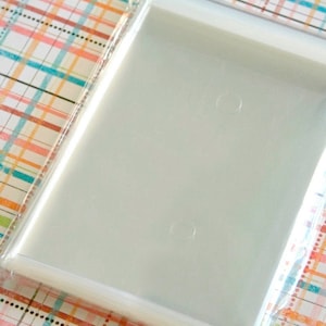 May include: A stack of clear plastic bags with a sealed opening. The bags are designed for packaging small items, such as jewelry or candy.