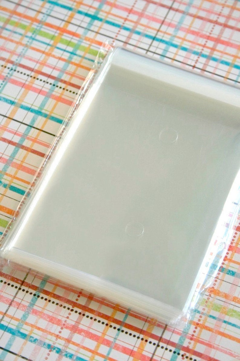 May include: A stack of clear plastic bags with a sealed opening. The bags are designed for packaging small items, such as jewelry or candy.