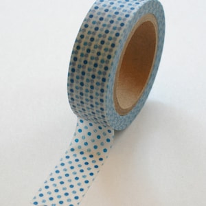 May include: A roll of blue and white washi tape with a polka dot pattern. The tape is on a white background.