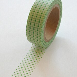 May include: A roll of green and white washi tape with a polka dot pattern. The tape is on a white background.