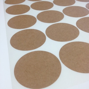 May include: Sheet of brown paper circle stickers on a white background.