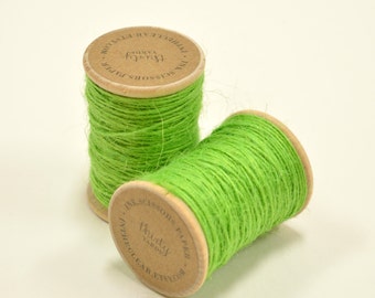 Puede incluir: Dos carretes de cuerda verde brillante, cada uno con una etiqueta de papel marrón que dice "Ink Scissors Paper Thirty Yards InTheClear Etsy.com".
