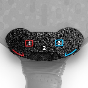 May include: Close-up of a black paddle with a textured surface. The paddle has a numbered dial with the numbers 1, 2, and 3. The dial has red and blue arrows.