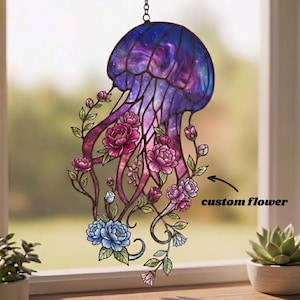 Puede incluir: Atrapasoles de medusa de vidriera con una cúpula con temática de galaxia y tentáculos fluidos. Adornado con flores y follaje rosas, moradas y azules. El texto "custom flower" es visible.