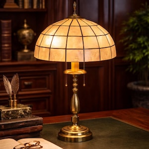 Statement heavy antique tone brass table lamp champagne capiz shell shade warm ambient lighting 23 inch tall luxury accent lamp. A conversa