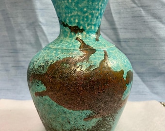 May include: A turquoise ceramic vase with a copper glaze. The vase has a wide base and a narrow neck.
