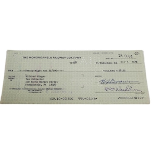 May include: A vintage Monongahela Railway Company check dated September 1, 1978, in Pittsburgh, PA. The check is made out to Mildred Winger, Tax Collector, for twenty-eight and 22/100 dollars, featuring printed text and handwritten signatures.