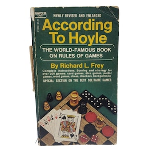 May include: A vintage book titled "According To Hoyle" with a green cover. The book features the text "The World-Famous Book on Rules of Games" and includes images of playing cards, chess pieces, and dice.