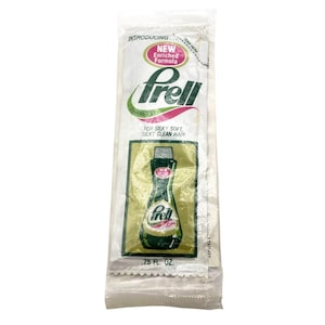 May include: A white plastic packet with a green and pink label. The label says "Introducing New Enriched Formula Frell Shampoo" and "For Silky Soft, Silky Clean Hair". The packet contains a .75 fl oz sample of Frell shampoo.