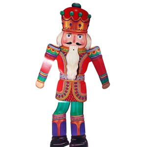 May include: A wooden Christmas nutcracker figurine. The nutcracker is painted in bright colors, including red, green, gold, and blue. It has a red crown, a white beard, and a detailed uniform. The figurine is designed to stand upright.