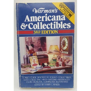 May include: A vintage book titled "Warman's Americana & Collectibles, 3rd Edition." The cover is blue with white and red text. The cover features a collage of collectibles, including a Mickey Mouse plush, a clock, and a lamp.