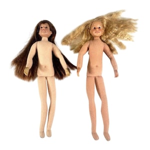 May include: Two vintage dolls with fabric bodies and plastic heads. One doll has long brown hair, the other has long blonde hair. Both dolls are nude and standing upright against a white background.