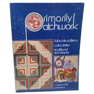 May include: A vintage book titled "Primarily Patchwork" with a blue cover. The cover features a patchwork design and the text "full-scale patterns, color plates, traditional techniques." The book is by Marjorie Puckett and Gail Giberson.