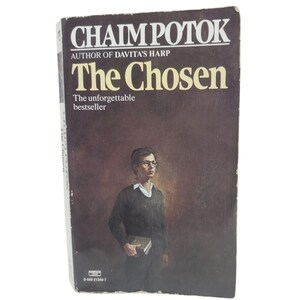 May include: A vintage paperback book titled "The Chosen" by Chaim Potok. The cover features a portrait of a young man in glasses holding a book, set against a brown background. The book's title and author's name are prominently displayed.