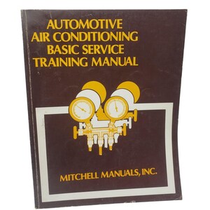 May include: A brown manual titled "AUTOMOTIVE AIR CONDITIONING BASIC SERVICE TRAINING MANUAL." The cover features a diagram of gauges and the text "MITCHELL MANUALS, INC." in a white frame.