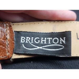 May include: A brown leather belt with a black label that says "BRIGHTON" in white lettering.