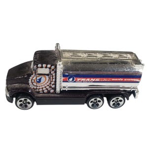 May include: A black and silver toy tanker truck with the text "TRANS-H2O WATER SYSTEMS". The truck has a detailed design on the cab and a shiny silver tank. The wheels are black with silver rims.