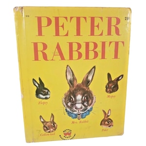 May include: A vintage hardcover book titled "Peter Rabbit" with a yellow cover and red lettering. The cover features illustrations of rabbits, including Mrs. Rabbit wearing glasses. The book is a Wonder Book.