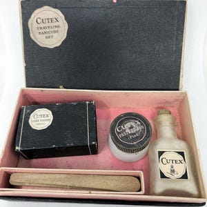 May include: A vintage black and pink travel manicure set with the brand name "CUTEX" on the lid and the items inside. The set includes a cake polish in white, a paste polish in pink, a bottle of polish remover, and a nail file.
