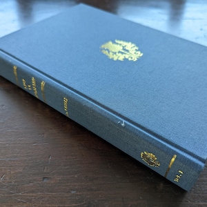 May include: A blue hardcover book with gold lettering and a gold design on the front cover. The title of the book is "The Complete Works of William Shakespeare".