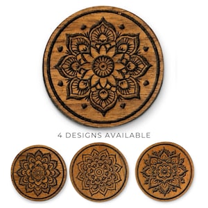 May include: Wooden coasters with a mandala design. The coasters are round and feature intricate floral patterns carved into the wood. The image shows four different designs available.