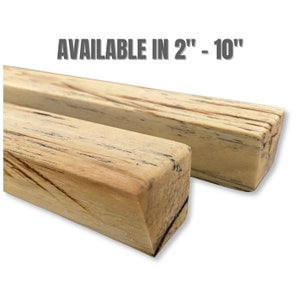 Puede incluir: Dos bloques de madera rectangulares con un patrón de vetas marrón claro y negro. El texto "AVAILABLE IN 2" - 10"" se muestra encima de los bloques. Los bloques miden aproximadamente 5 a 25 cm de largo.