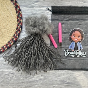 May include: An assortment of gray dreadlocks, two pink crochet hooks, and a decorative sticker with the text "Beautifullocs". The dreadlocks are arranged on a light gray and white wooden surface. A woven coaster is in the upper left corner.