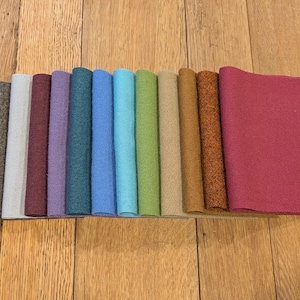 May include: A collection of 10 fabric swatches in various colors, including brown, beige, burgundy, purple, teal, blue, turquoise, green, tan, and rust.