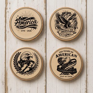 Op de afbeelding: Vier houten onderzetters met patriottische ontwerpen. E&eacute;n onderzetter toont het woord "America" met "1776-2026". Andere tonen een adelaar met de teksten: "America 250", "250 Years of American" en "July 4th 2026".
